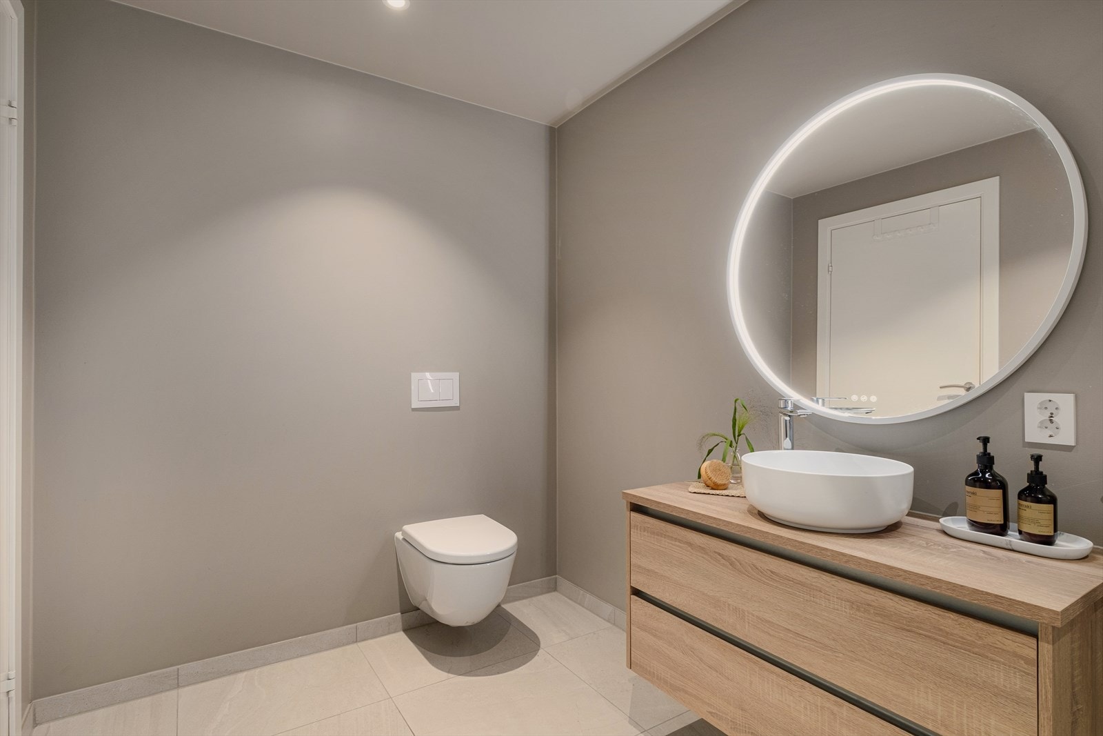 Badet er innredet med vegghengt toalett, servant med innredning, speil m/belysning, og dusj. Galleribilde