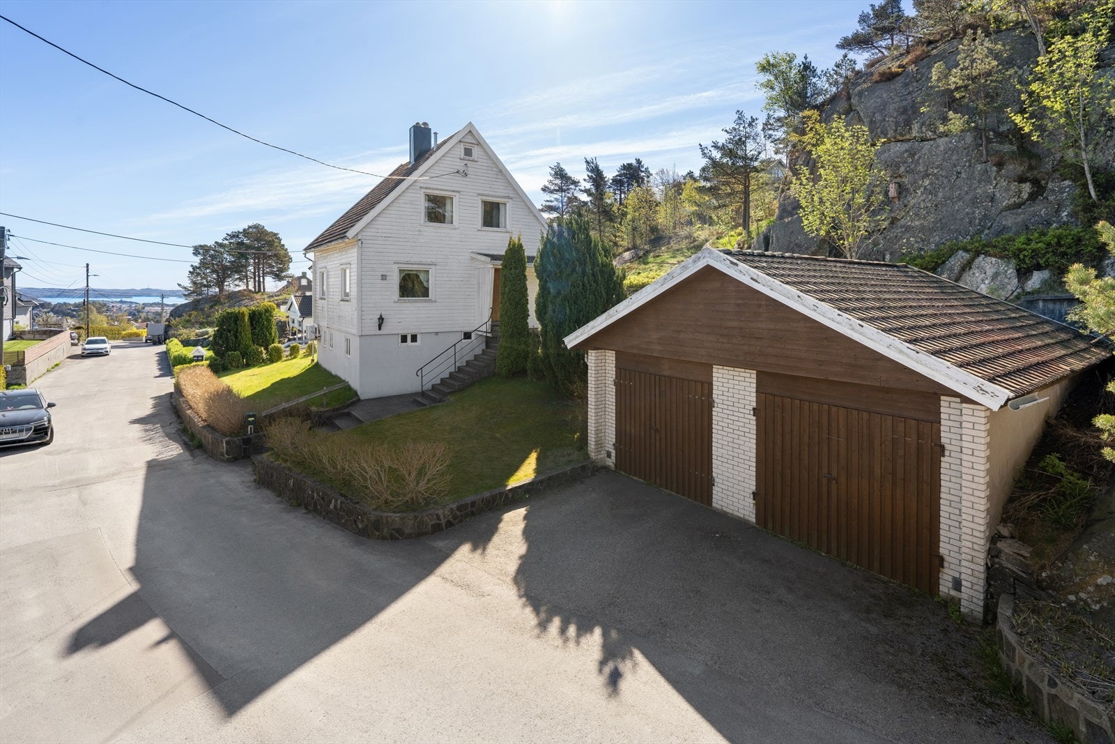 Tomten er planert og innbydende rundt boligen, med betongplatting, hage og diverse beplanting. Galleribilde