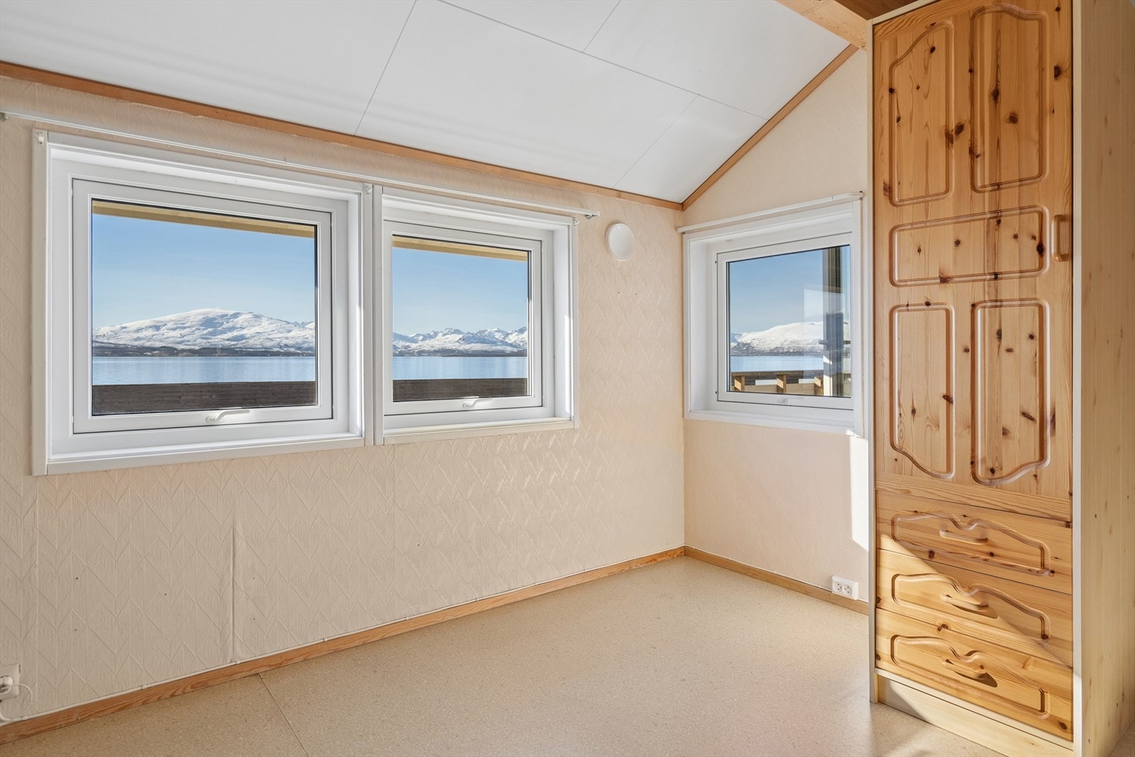 Fra soverommet kan du våkne til en nydelig utsikt mot Tromsøysundet, med de majestetiske fjellene som et rolig og stemningsfullt bakteppe. Galleribilde