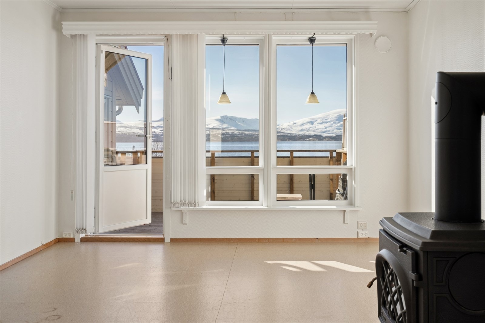 De store vinduene rammer inn den praktfulle utsikten mot Tromsøysundet, hvor Kvaløyas snødekte fjell danner et storslått og stemningsfullt bakteppe året rundt. Galleribilde