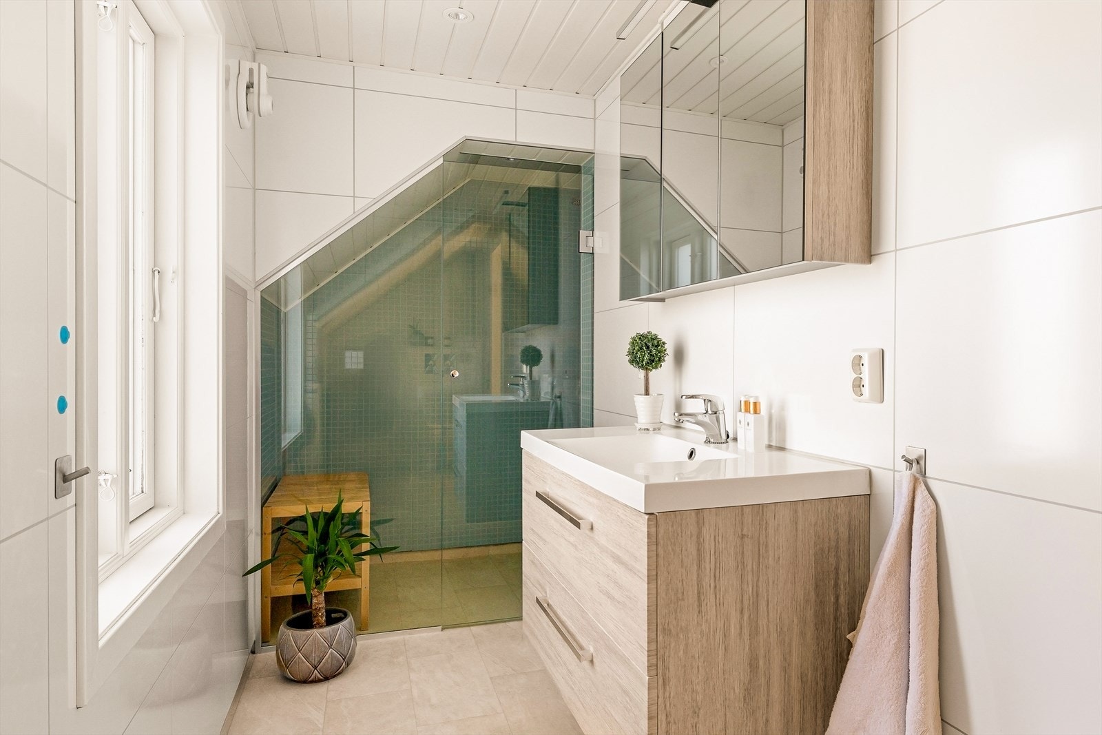 Badet er innredet med servant, speilskap, vegghengt toalett og dusjnisje. Galleribilde