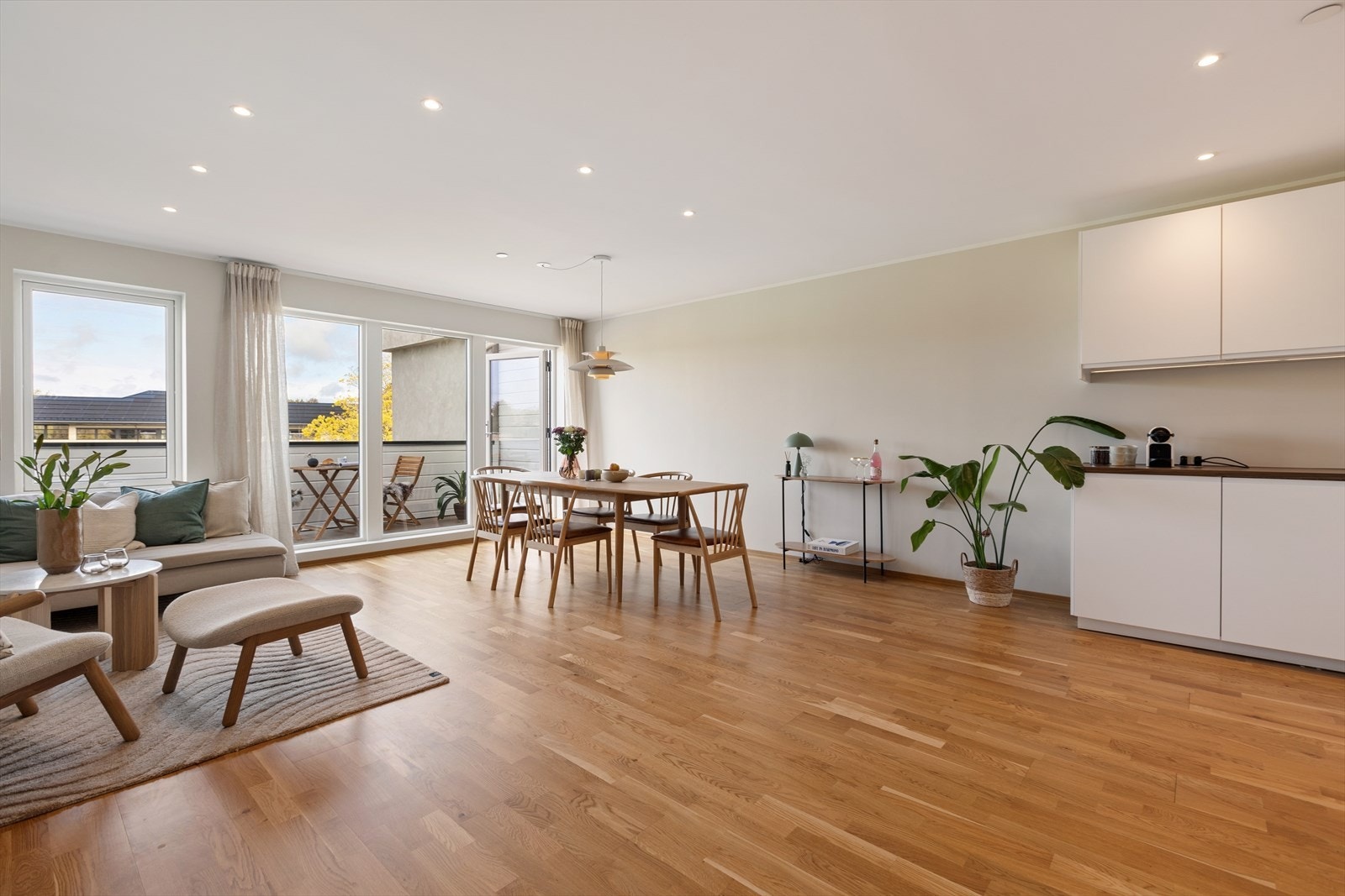 Videre inn til stuen møtes du av en åpen løsning fra kjøkken-stue med spotter i tak, lyse overflater og store vindusflater som leder veien ut til en terrasse m/kveldssol som kan nytes. Galleribilde