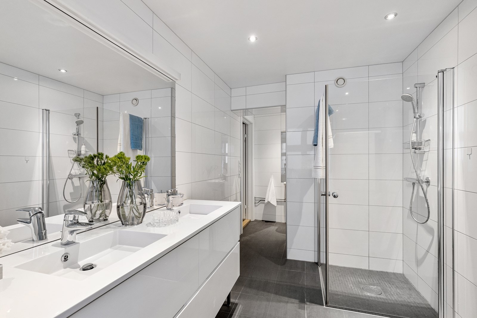 Her finner du innfellbare dusjdører, veggmontert wc og servant med ettgreps blandebatteri fra Grohe. I tillegg har badet servantskap med dobbel servant, ettgreps blandebatteri fra Grohe og Hansgrohe. Galleribilde