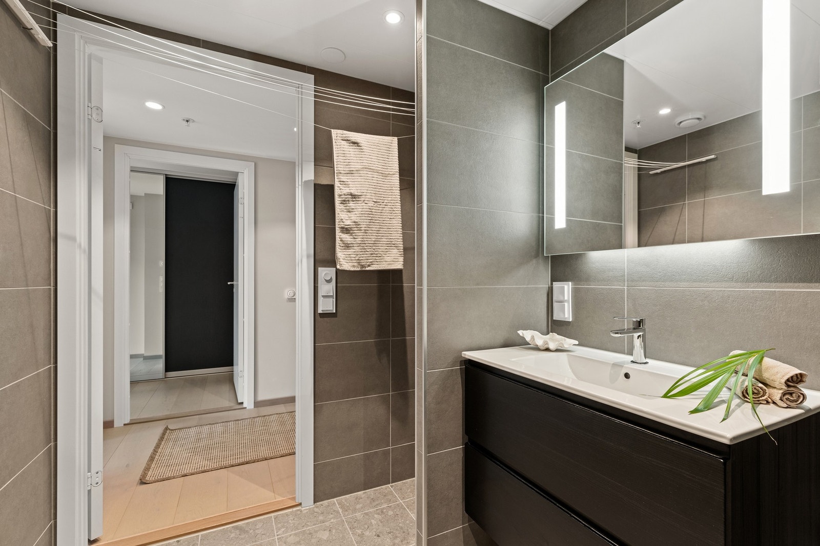 Badet har heldekkende servant med skuffeseksjon, og speil med integrert belysning. Galleribilde
