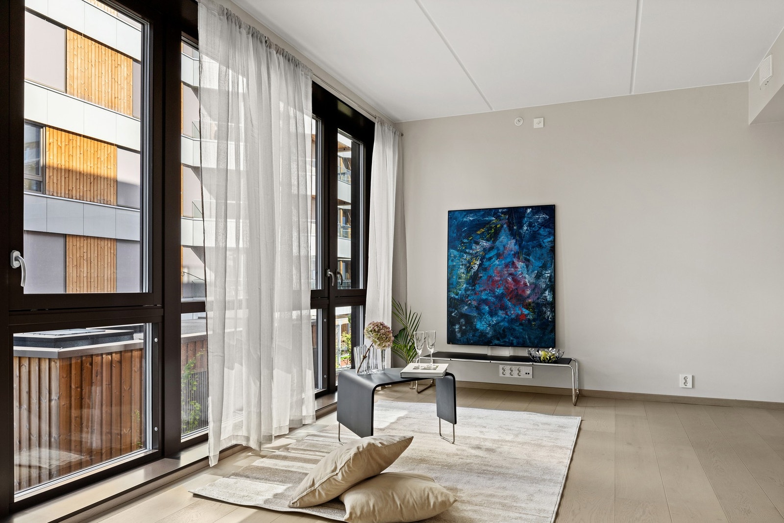Stue med rom for møblering i soner. Det er pent dekke av enstavs parkett på gulv i entré, stue/kjøkken og soverom Galleribilde