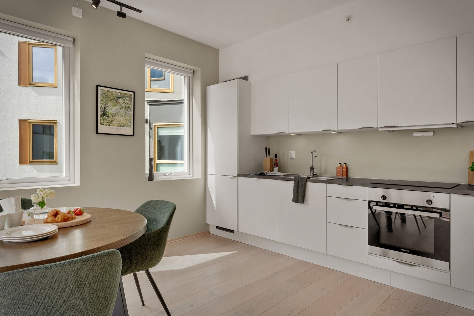 - Kjøkkenet ligger i åpen løsning mot stuen og fremstår lyst, moderne og pent med slette fronter og godt med skap- og benkeplass - Galleribilde