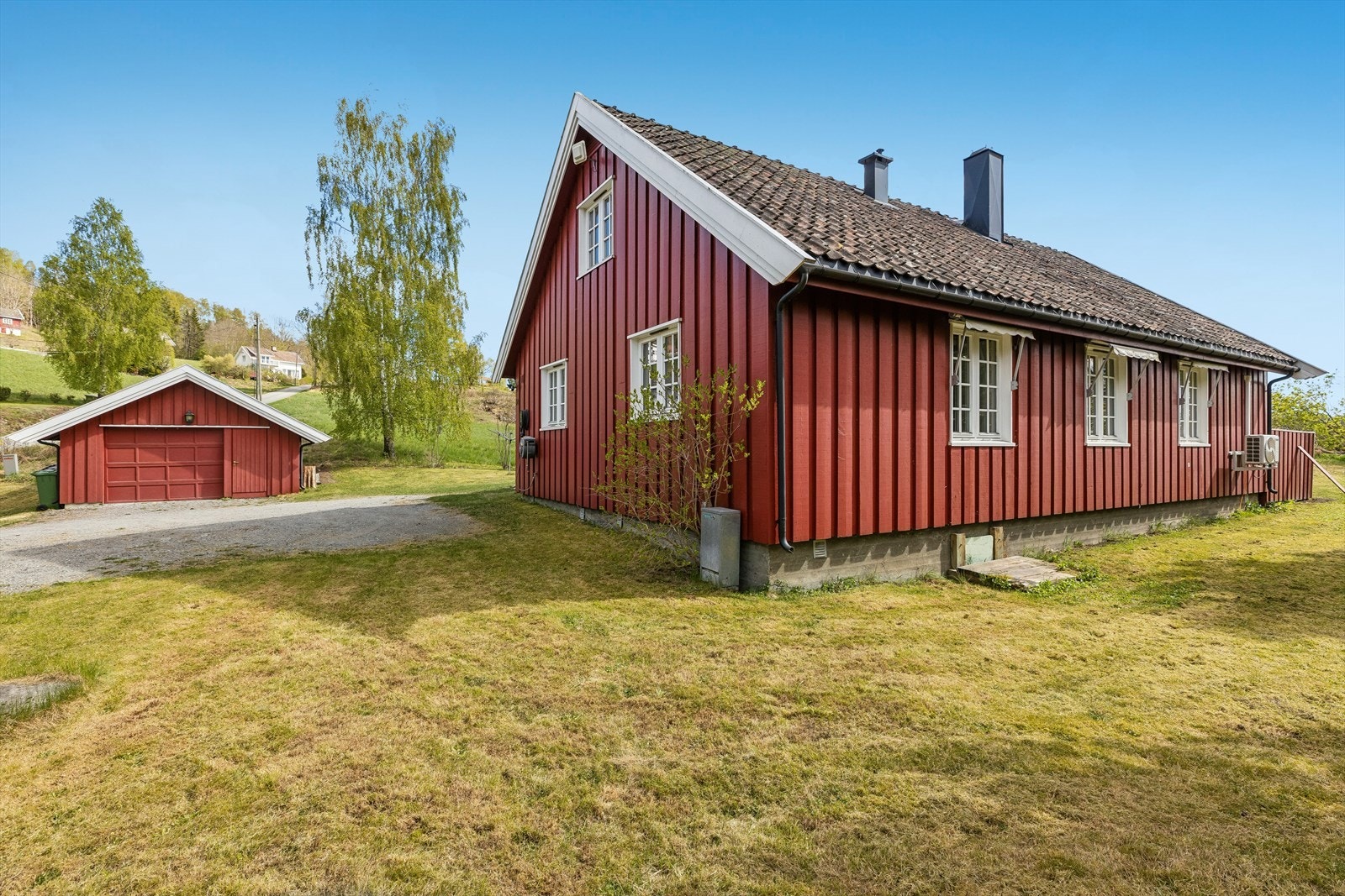 Eiendommen har en gruset gårdsplass og en frittstående garasje. Galleribilde