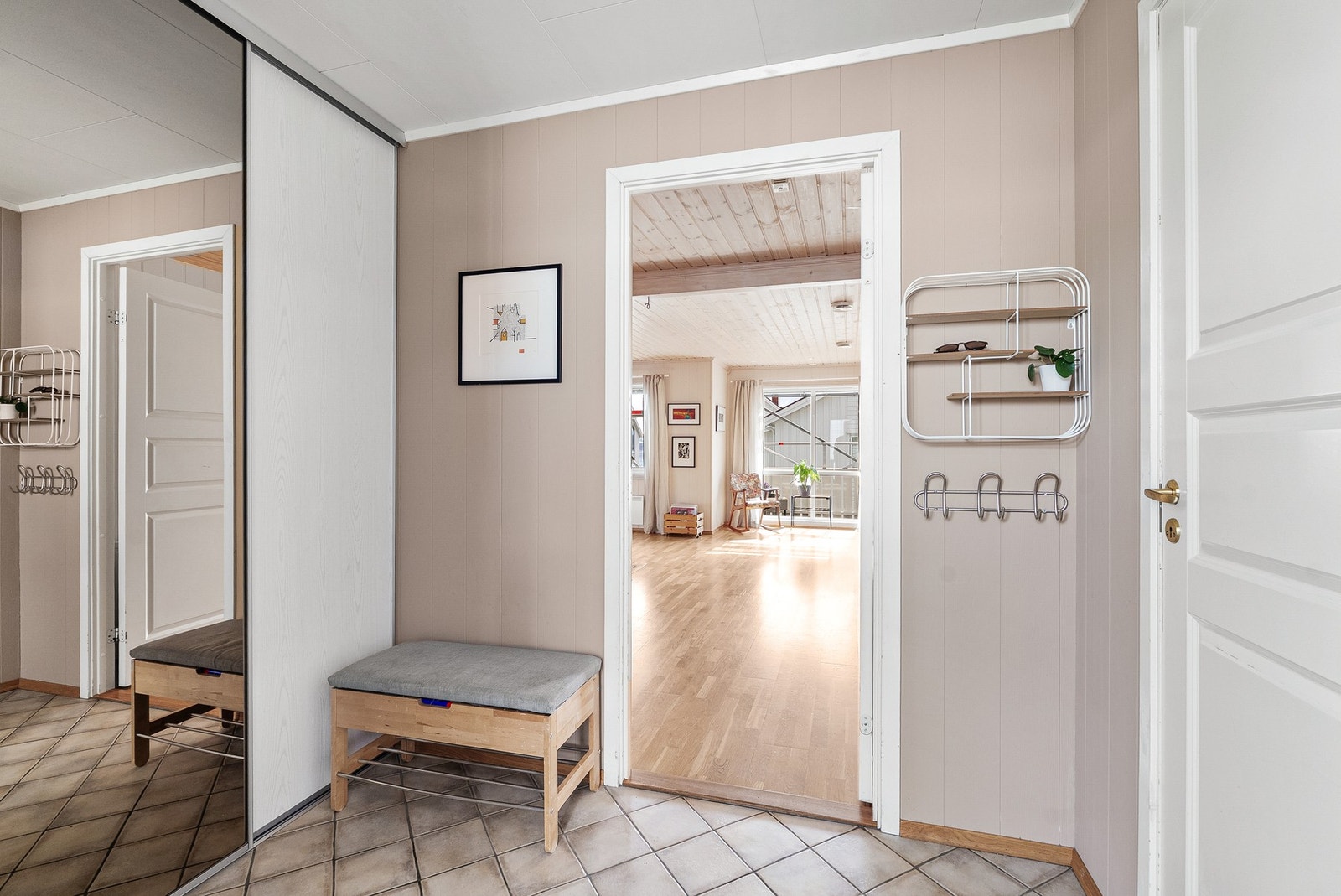 Vindfanget har et praktisk, flislagt gulv med varmekabler og god plass til oppbevaring av yttertøy i skyvedørsgarderobe. Galleribilde