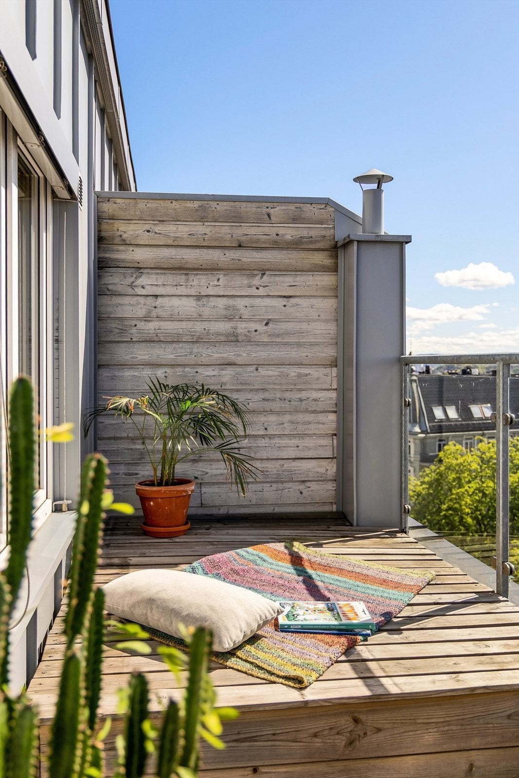 En skjermet krok på terrassen gir plass for en egen loungesone. Galleribilde