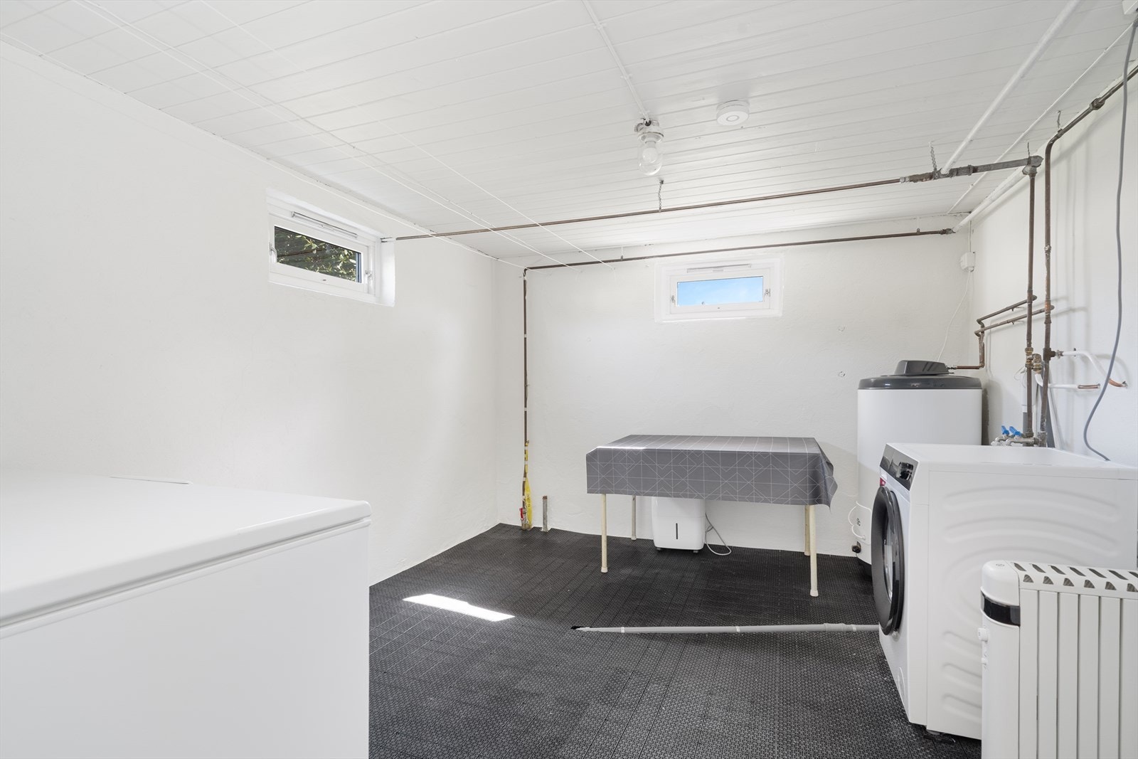 Praktisk og romslig vaskerom i kjelleren med opplegg for vaskemaskin. Galleribilde