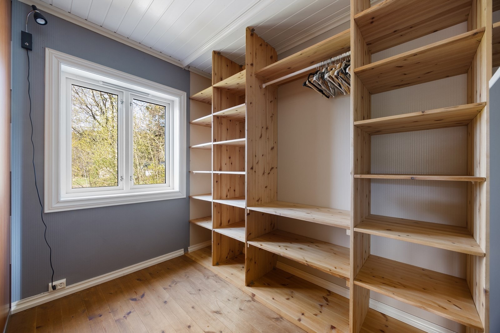 Garderoben har en åpen og oversiktlig innredning med hyller og oppheng. Galleribilde