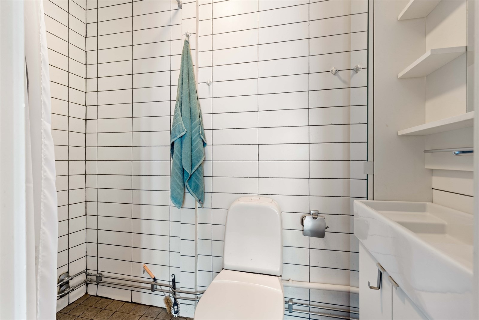 Flislagt bad med elektriske varmekabler. Badet er utstyrt med innredning med nedfelt servant, toalett og dusjhjørne med dusjvegger. Galleribilde