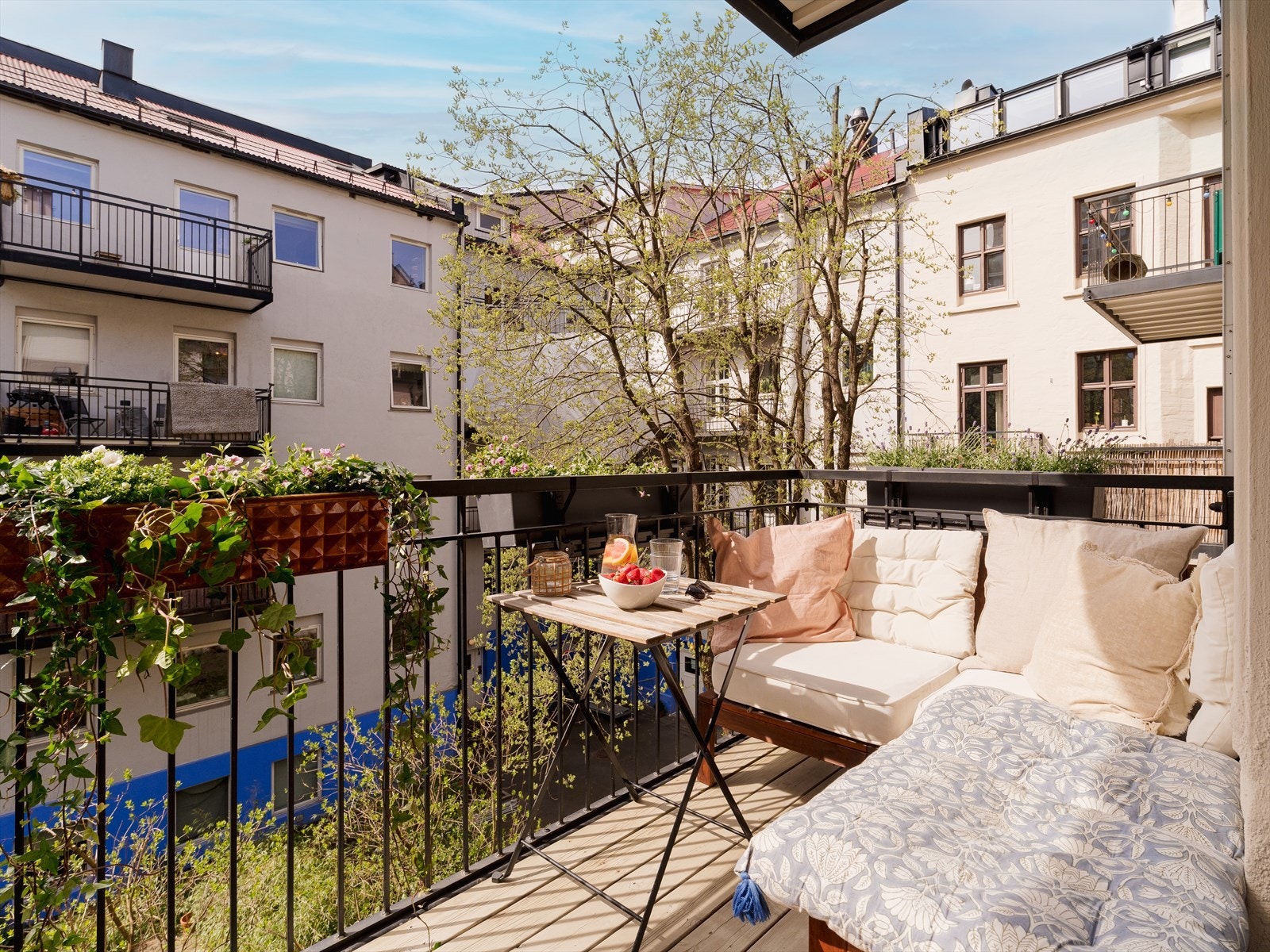Lun og skjermet balkong vendt mot frodig bakgård med plass til både sittegruppe og blomsterkasser, et ekstra rom i sommerhalvåret. Galleribilde