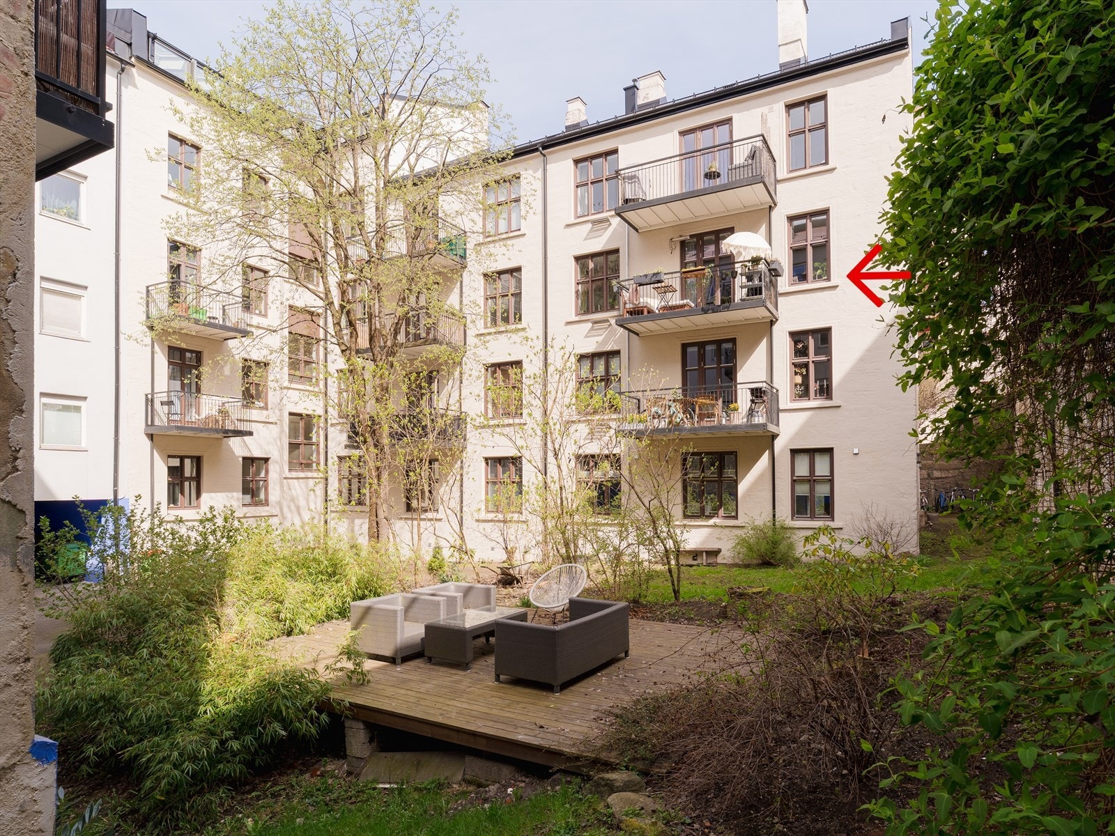 Rolig og skjermet bakgård med grønne omgivelser som gir en fredelig atmosfære midt i byen. Galleribilde