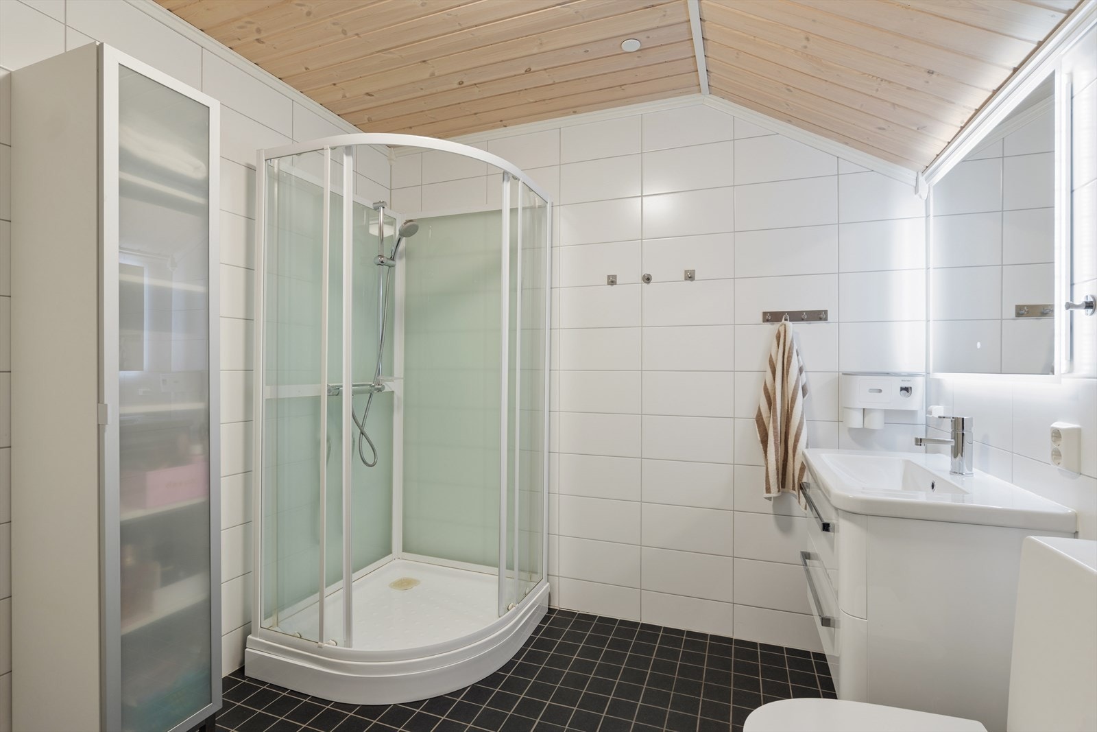 Badet i loftsetasjen er i samme utførelse som badet i 2. etasje, med sorte fliser på gulv og hvite fliser på vegger. Galleribilde