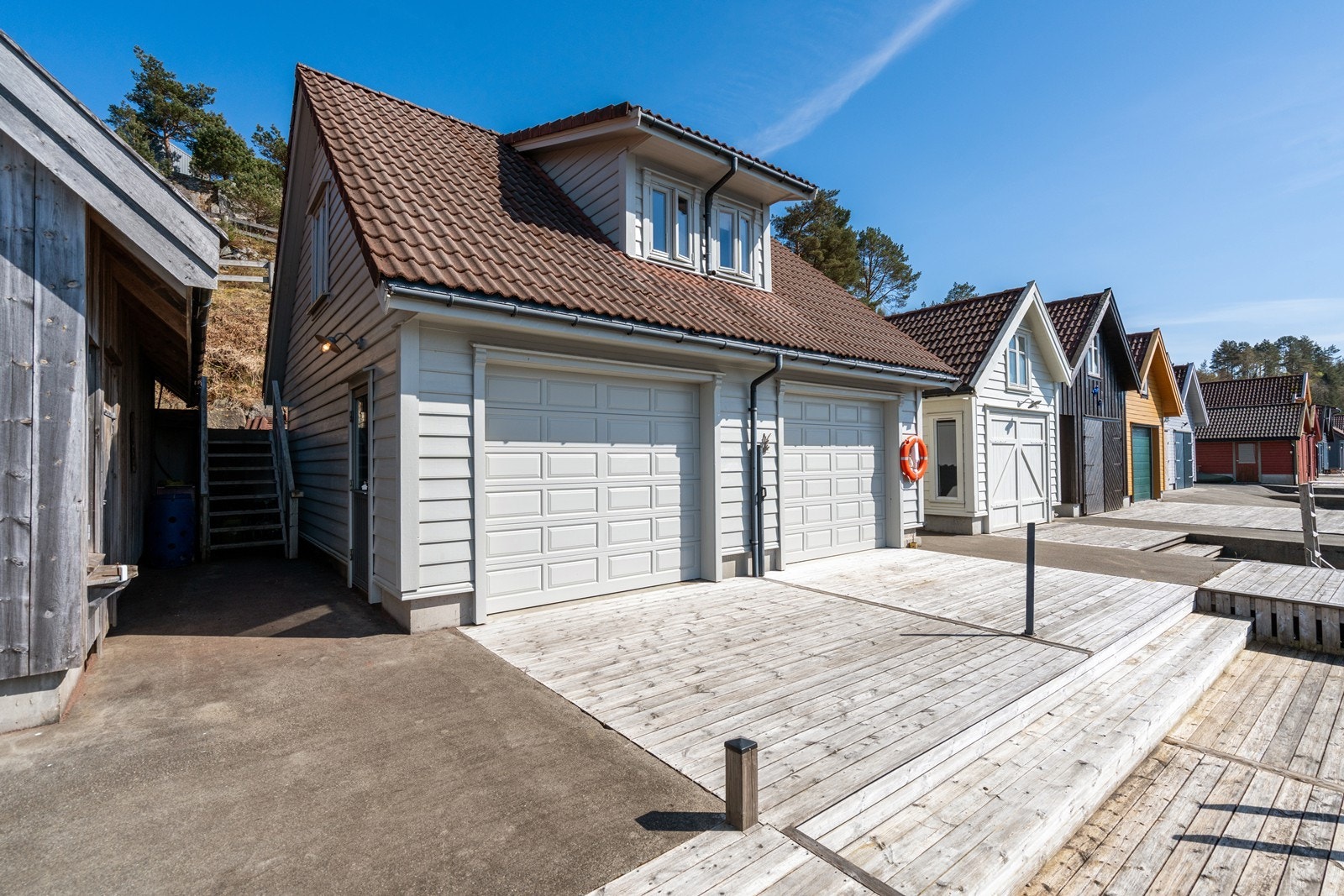 Naust og brygge ligger idyllisk til like nedenfor boligen Galleribilde