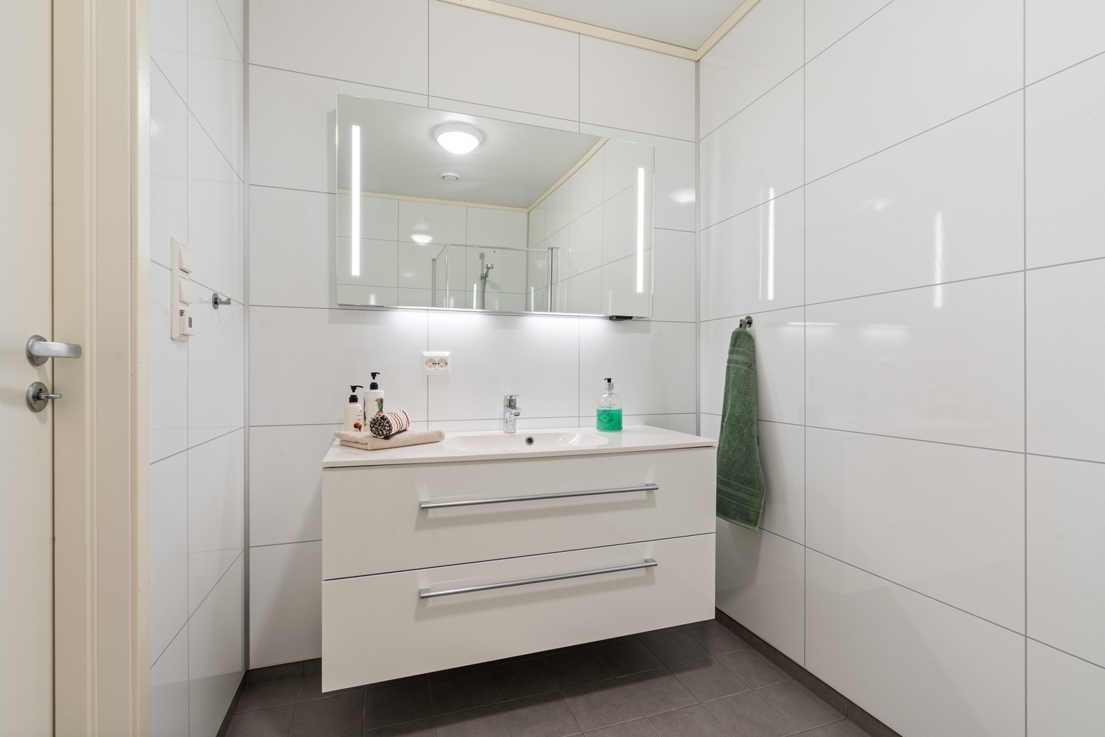 Badet er innredet med nedfelt servant, veggmontert toalett og dusj. Galleribilde