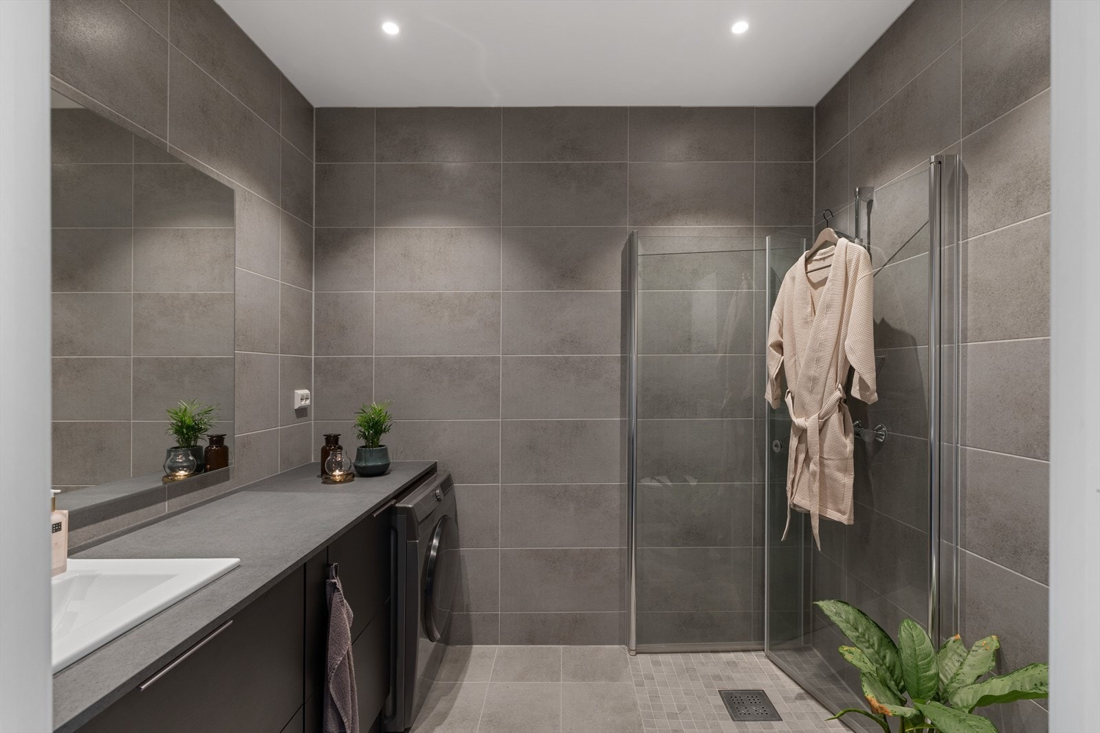 Badet har en stilren utforming med sorte detaljer som harmonerer med kjøkkenet. Galleribilde