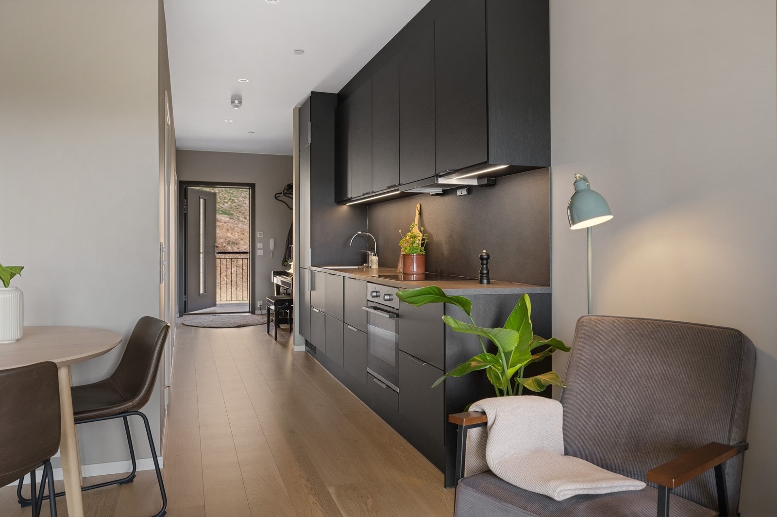 Kjøkkenet fremstår moderne med sorte fronter og grå benkeplate. Galleribilde