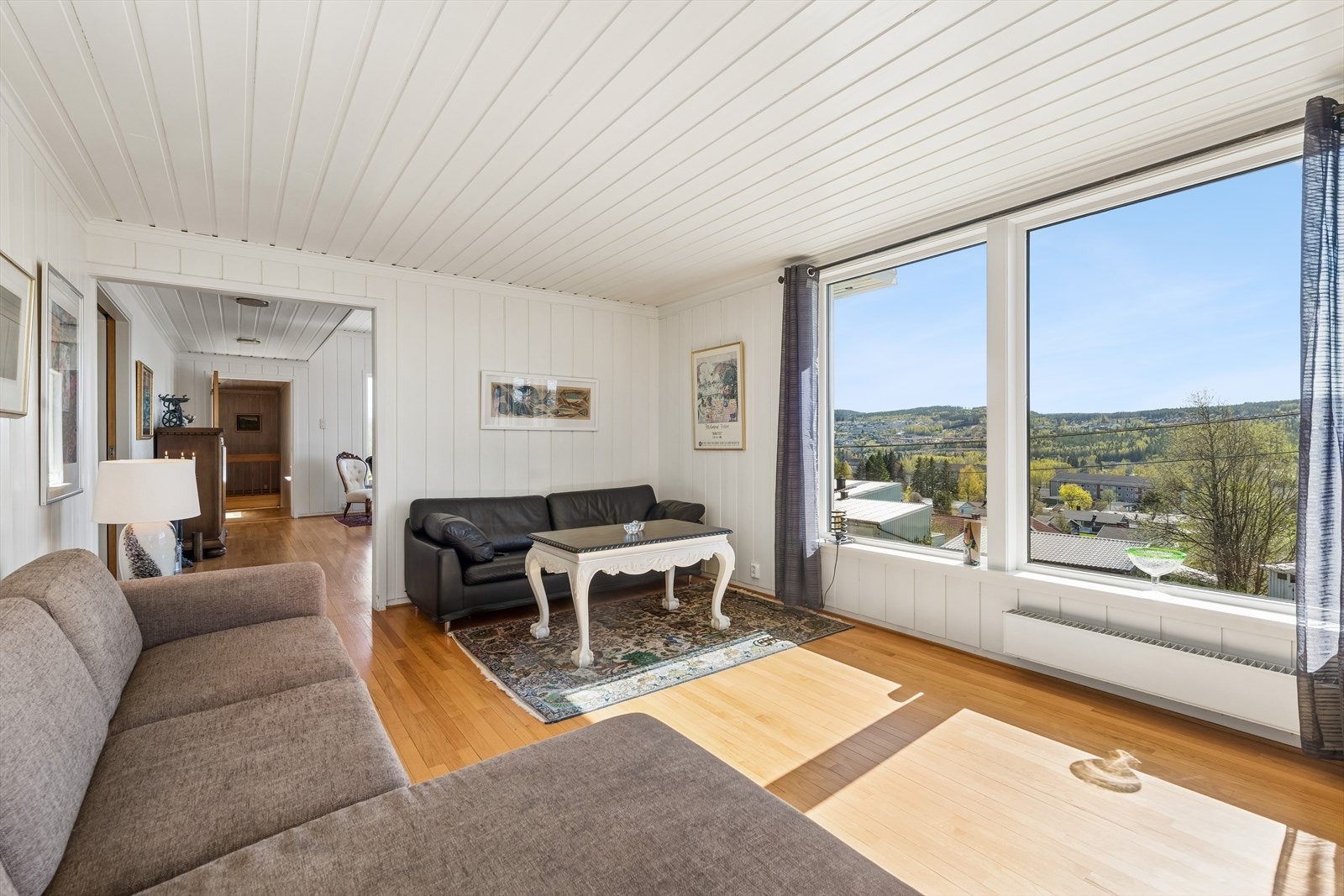 Stuene har hvitmalt panel på tak og vegger, og eikeparkett på gulv. Galleribilde
