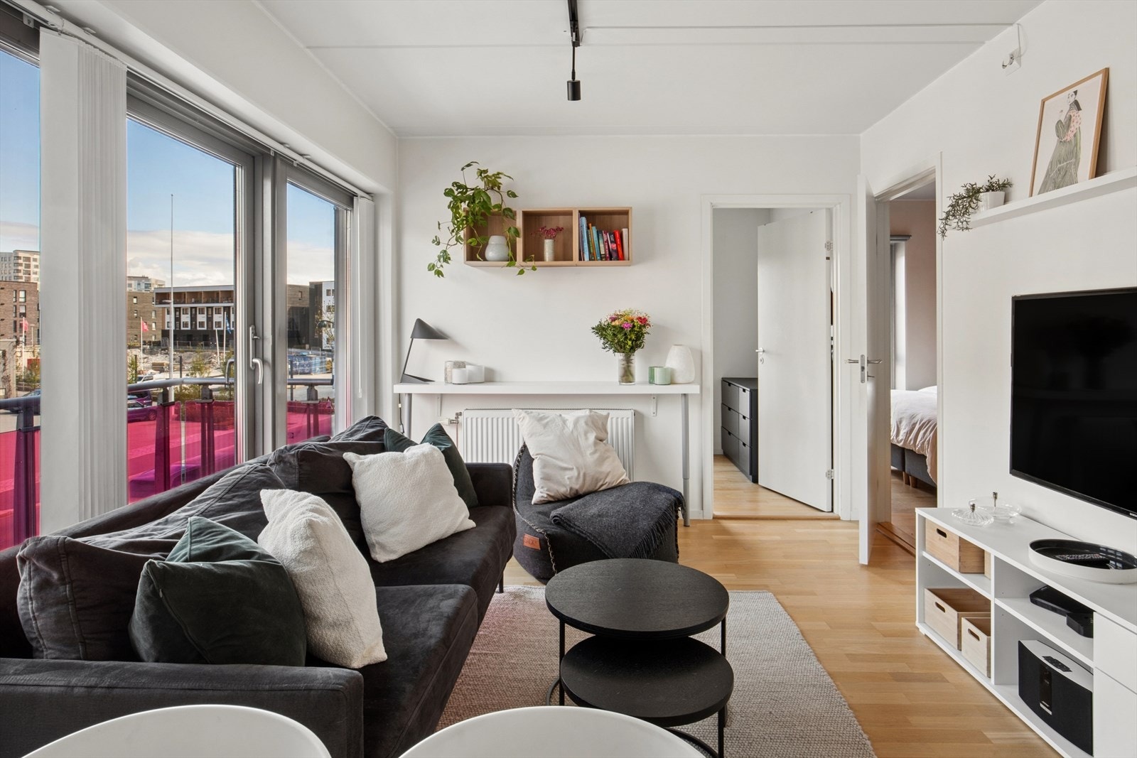 Et lyst oppholdsrom med plass til sofa med tilhørende møblement. Galleribilde
