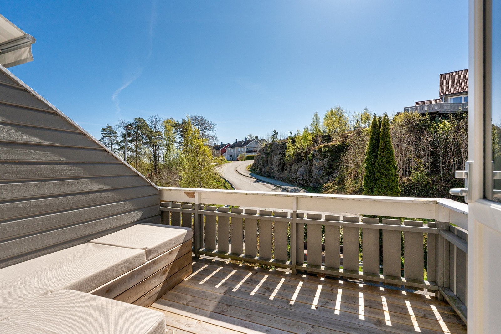 En solrik veranda med plassbygget utesofa, varmelampe. Galleribilde