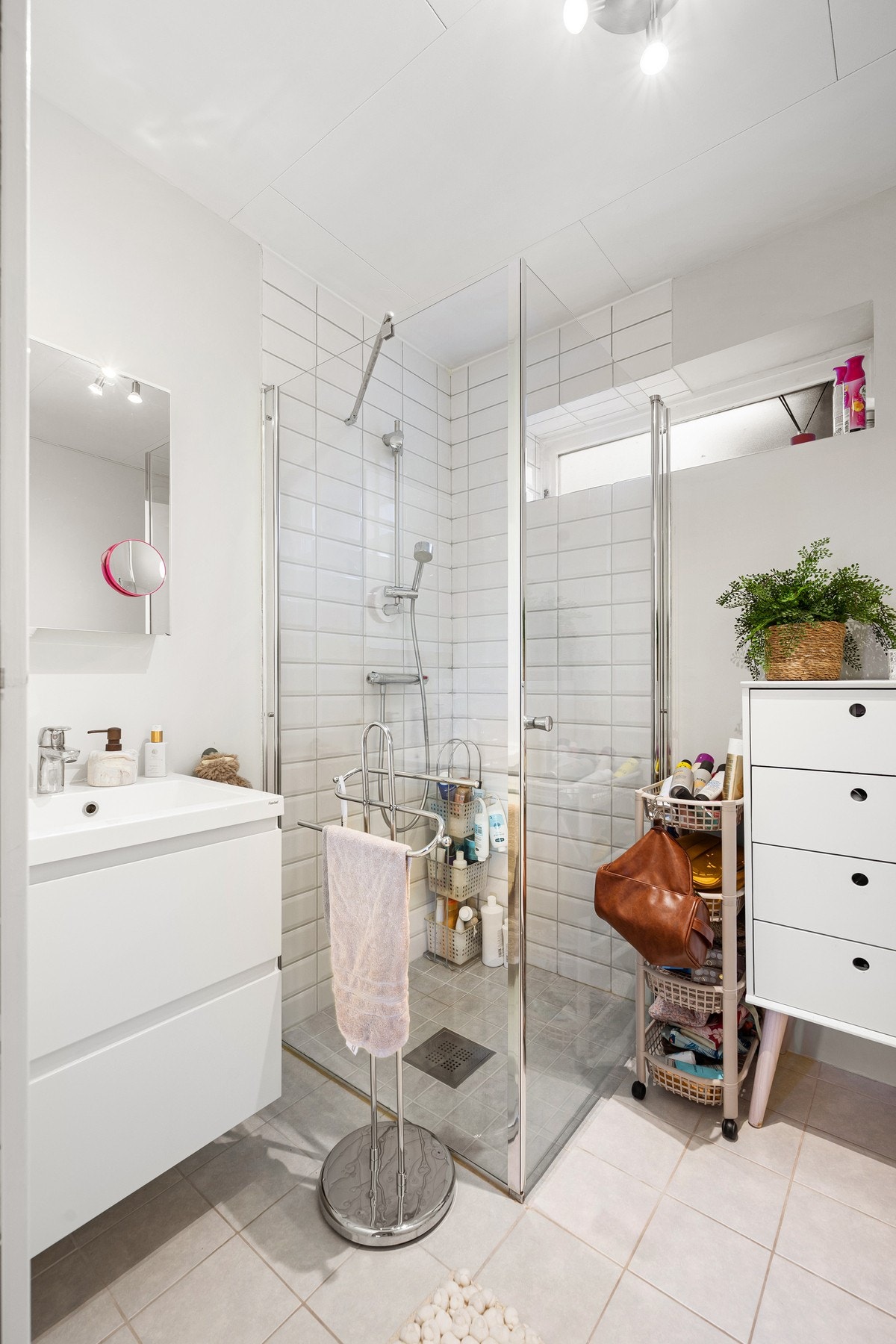 Badet har flislagt gulv med varme og inneholder baderomsinnredning, dusjnisje og toalett Galleribilde