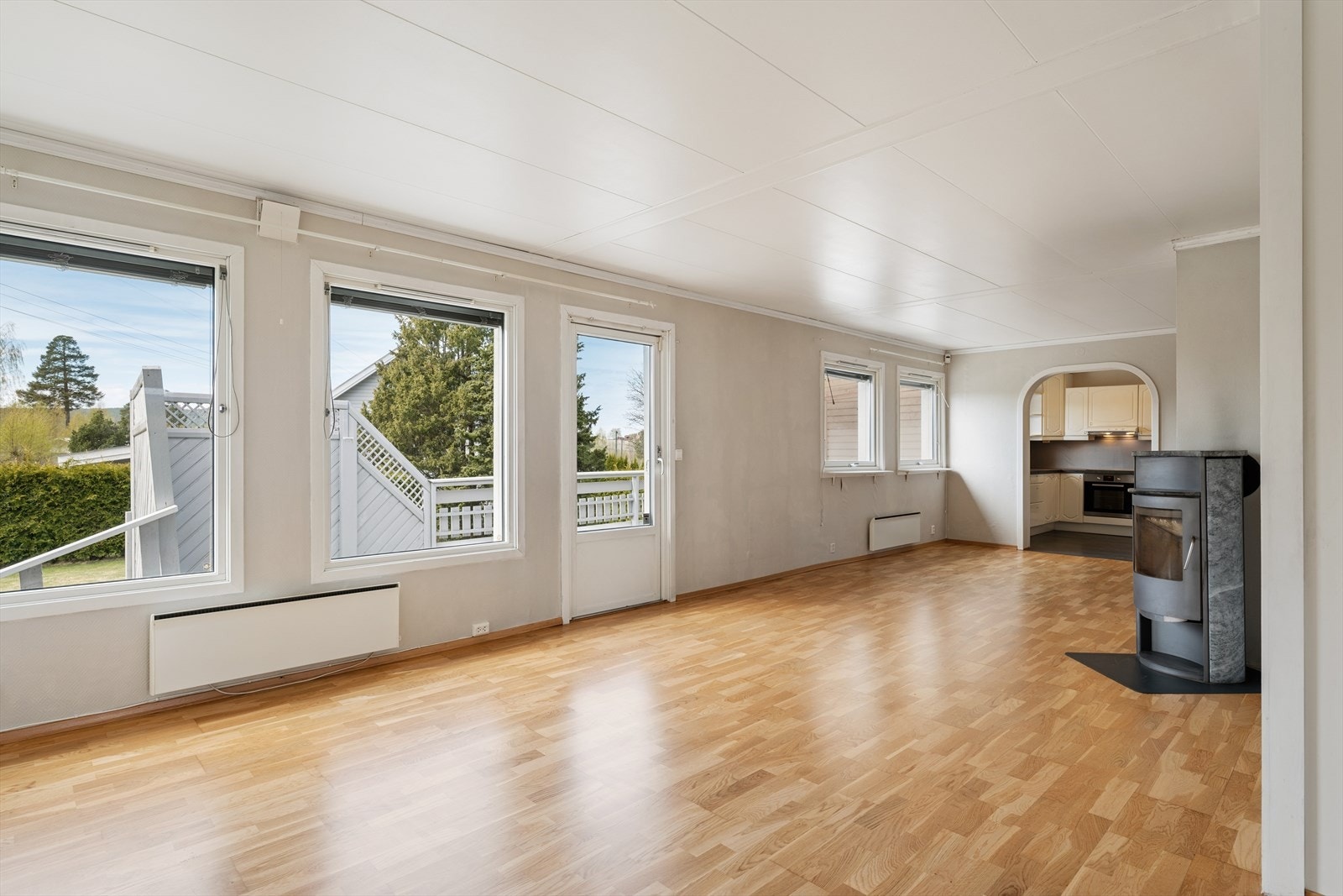 Stuen har parkett på gulvet og en åpen buegang mot kjøkkenet. Galleribilde