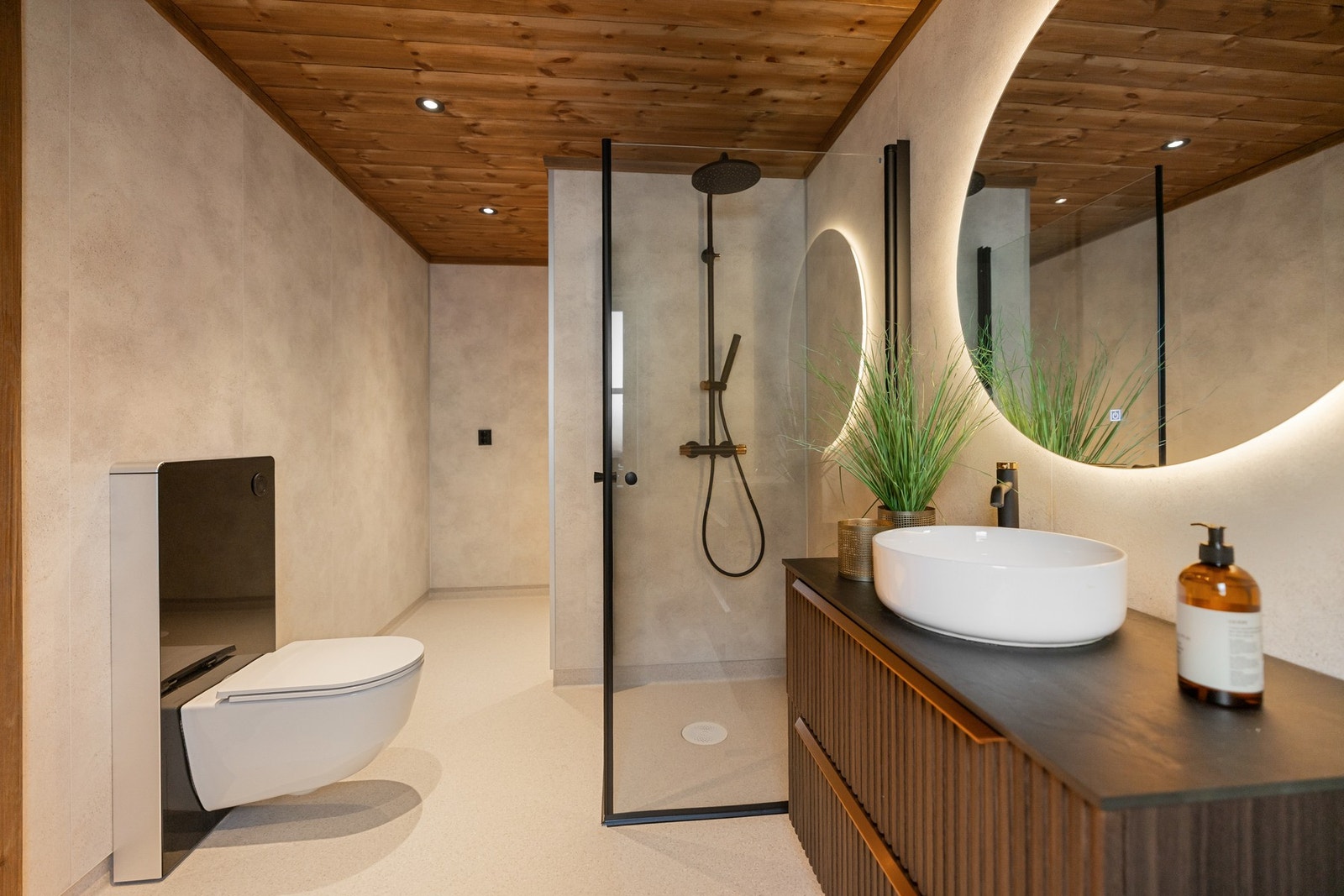 Dusjsonen er utstyrt med glassvegger, regnfallsdusj og hånddusj i sort utførelse. Badet har også gulvstående toalett og opplegg for vaskemaskin. Galleribilde