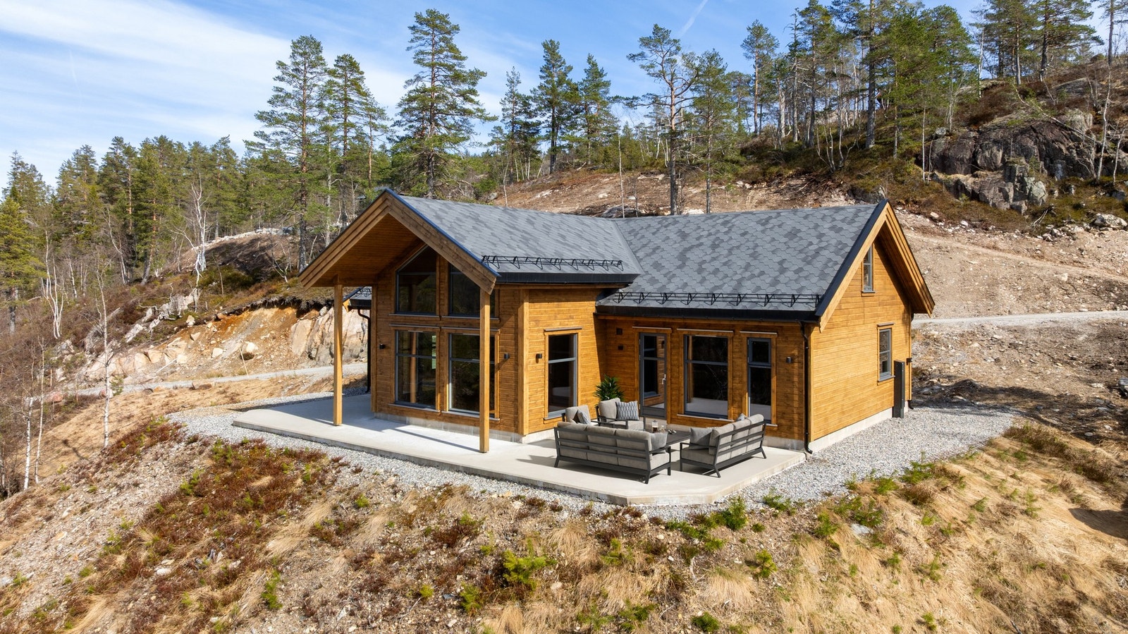 Hytta ligger flott til på tomten med gode uteområder, store vindusflater og gjennomført arkitektur som passer naturlig inn i terrenget. Galleribilde
