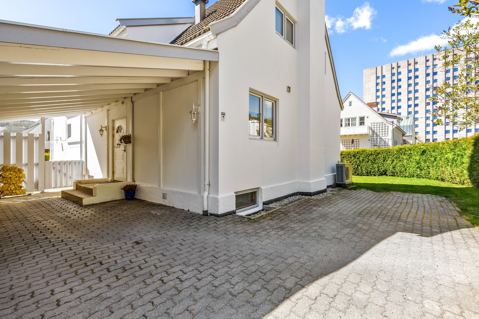 Boligen har gode parkeringsmuligheter i carport og hellelagt gårdsplass Galleribilde