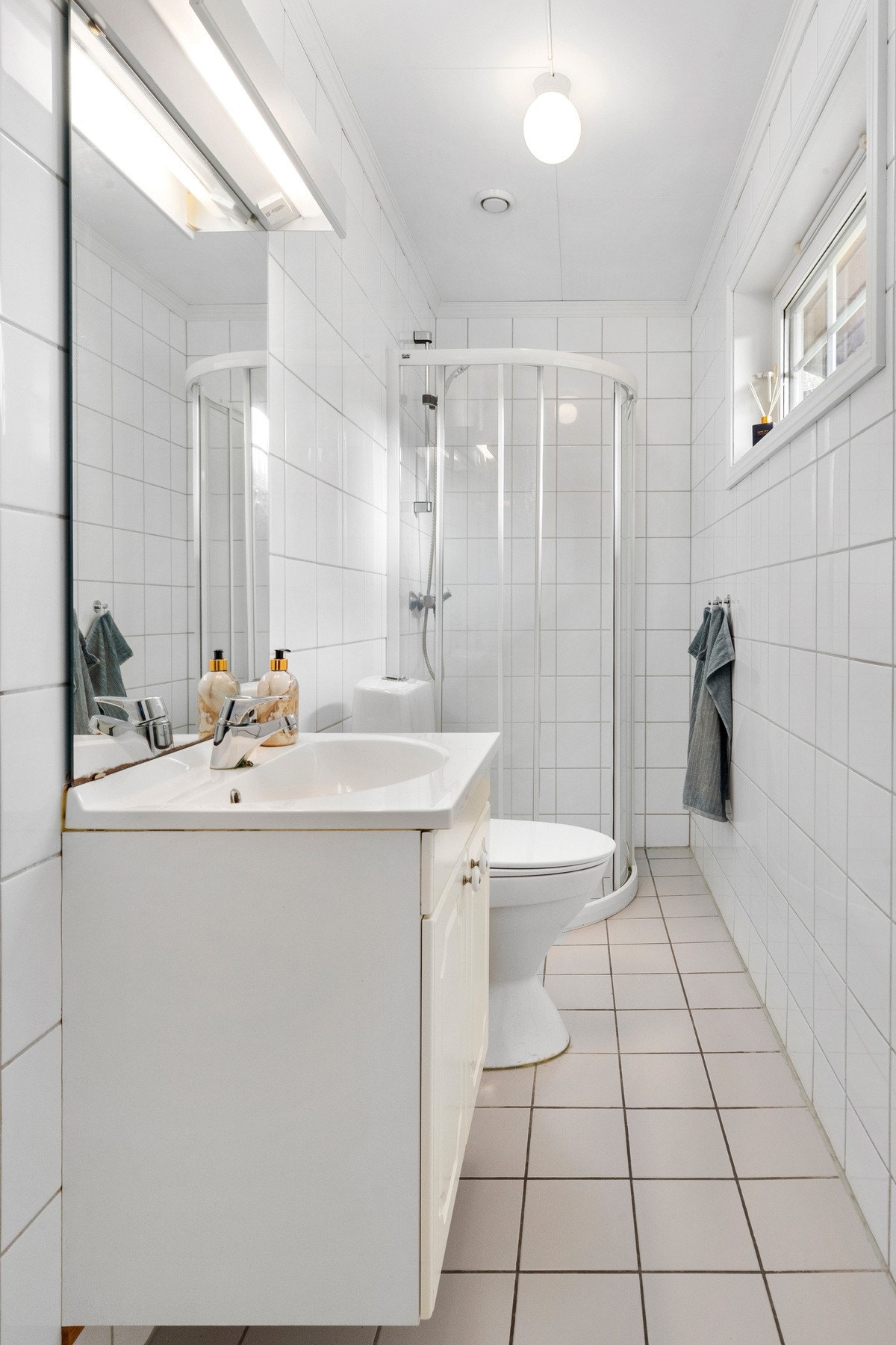 Flislagt baderom i 1. etasje med gulvvarme, dusjhjørne, wc, servantskap og mekanisk avtrekk. Galleribilde