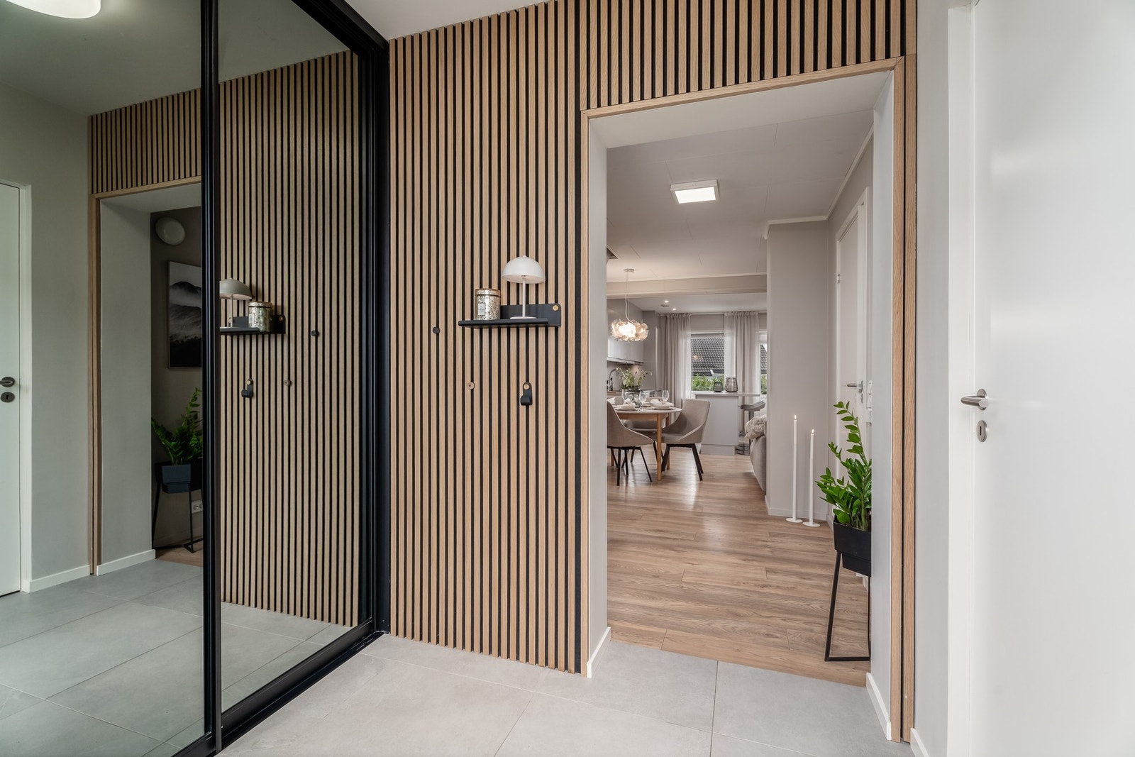 Velkommen inn! Lys og romslig entrè med praktisk skyvedørsgarderobe Galleribilde
