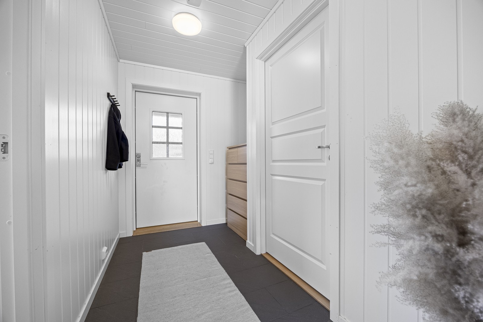 Flislagt gulv og malte mdf plater på vegger gir et praktisk og vedlikeholdsvennlig inngangsparti. Varmekabler. Galleribilde