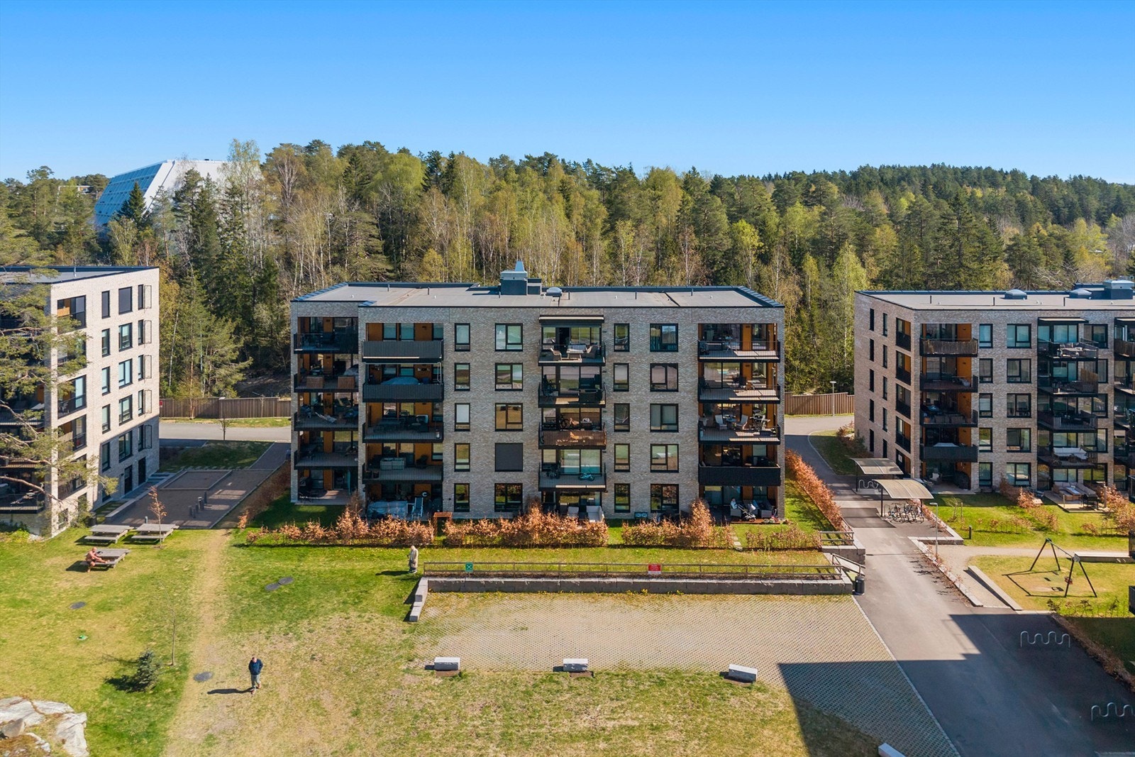 Området består av moderne leilighetsbygg med store, grønne fellesarealer mellom bygningene. Galleribilde