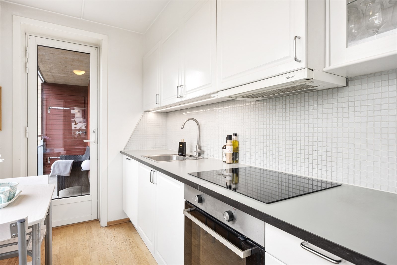 Kjøkkenet har godt med skap- og benkeplass. Integrert ovn og oppvaskmaskin, frittstående kjøleskap. Fra kjøkkenet er det direkte utgang til balkongen. Galleribilde