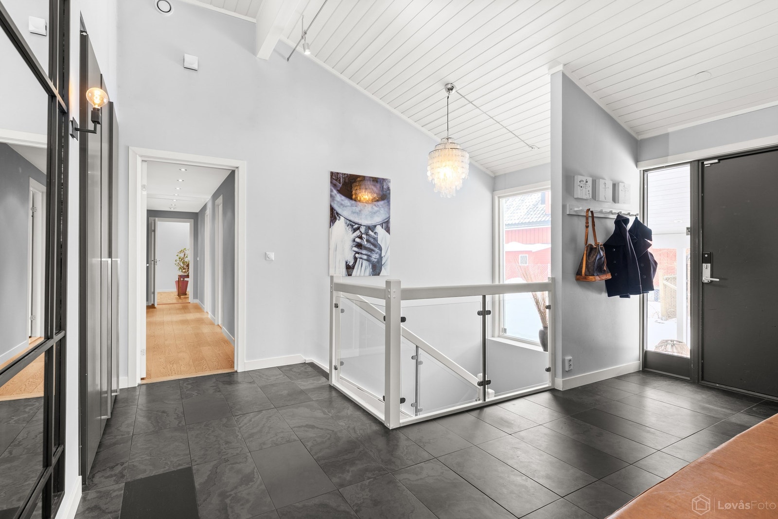 Boligen ønsker deg velkommen med en lys og generøs entré som setter tonen for resten av hjemmet. Gulvet er belagt med fliser med behagelig gulvvarme. Galleribilde