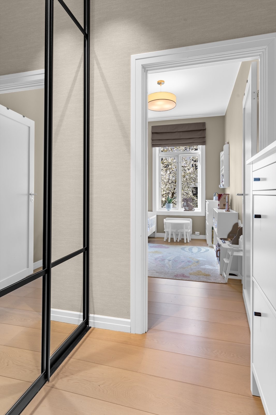 Mellomgang ved entréen med romslig og plassbygget skyvedørsgarderobe med speilfronter fra Skapnett (montert i 2023). Garderoben er hele 90 cm dyp og har praktisk innredning med hyller, skuffer samt både kort og langt heng. Skoskap medfølger. Galleribilde