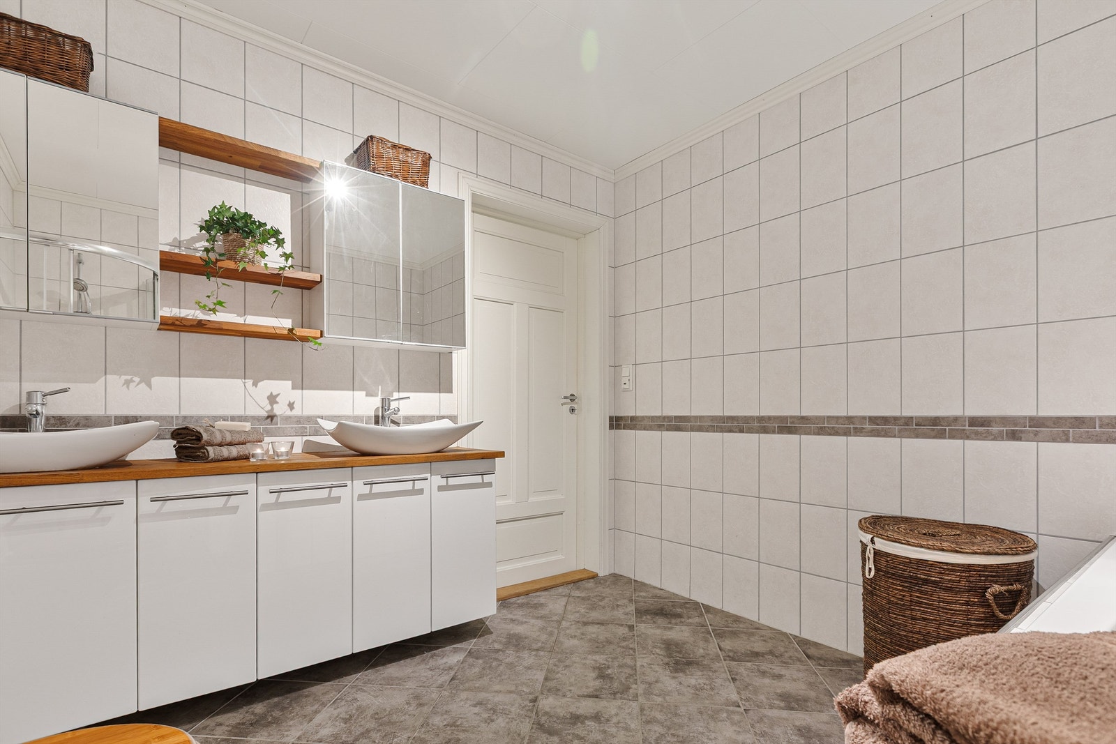 Badet er utstyrt for en travel hverdag med doble servanter, speilskap og varme i gulvet. Galleribilde