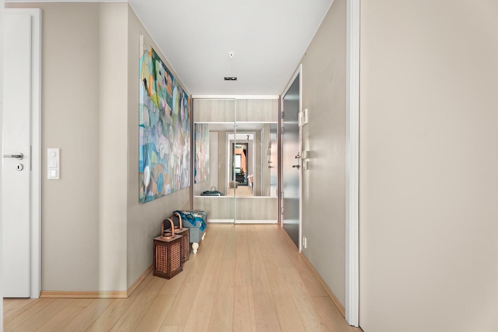 En romslig skyvedørsgarderobe med speilfronter i gangen gir rikelig med oppbevaringsplass for yttertøy og sko. Galleribilde