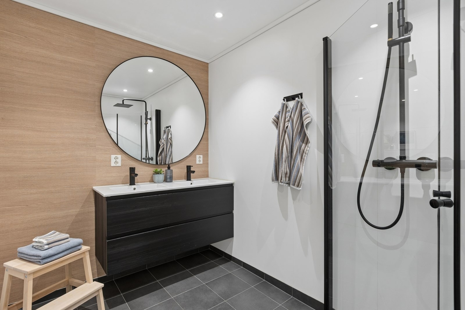 Badet er utstyrt med en bred servantinnredning med doble skuffer og et stort, rundt speil. Galleribilde