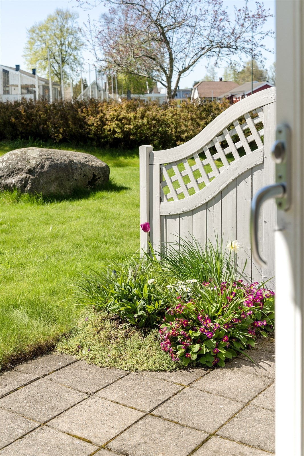 Tomten er pent opparbeidet med plen og beplantning. Galleribilde