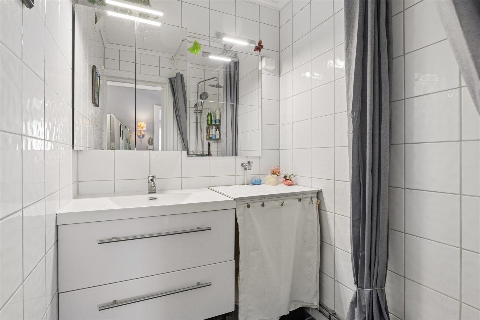 Badet er utstyrt med dusjhjørne og en servantinnredning med god oppbevaringsplass. Galleribilde