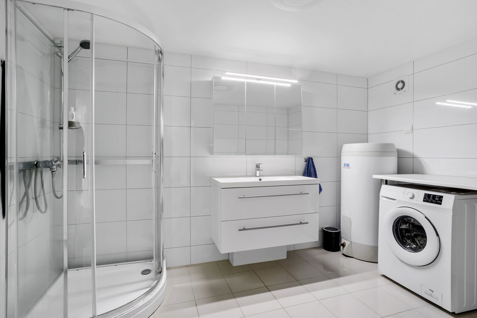 Lyst og flislagt bad med gulvvarme og opplegg for vaskemaskin. Galleribilde
