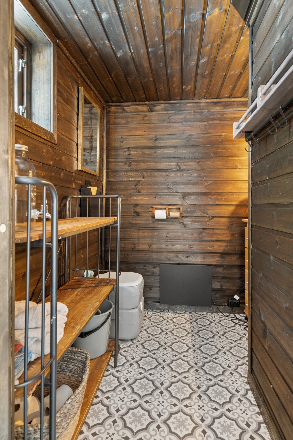 Badet har et sjarmerende preg med mønstrede gulvfliser og panel på veggene. Galleribilde