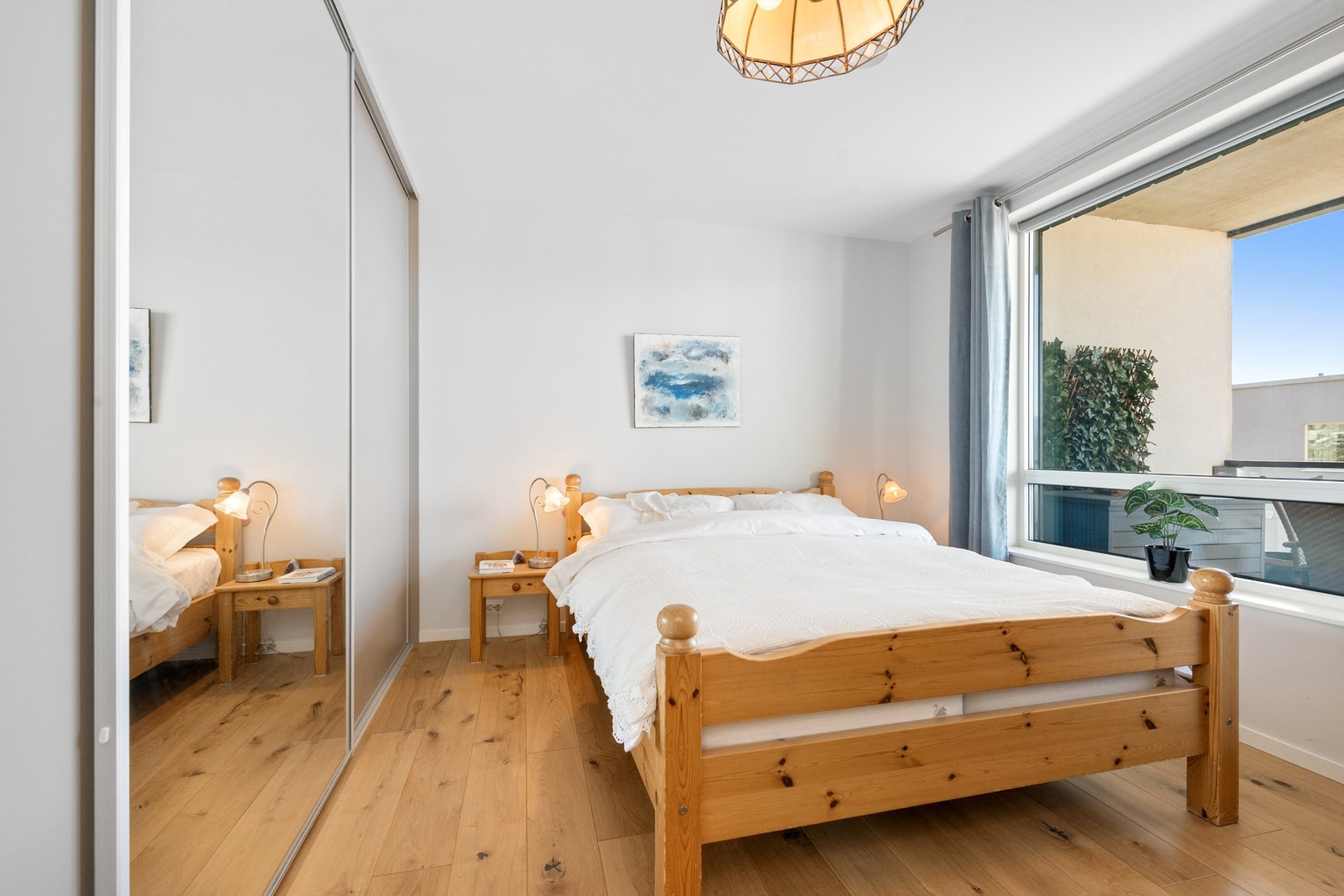 En romslig skyvedørsgarderobe med dels speilfronter gir rikelig med oppbevaringsplass Galleribilde