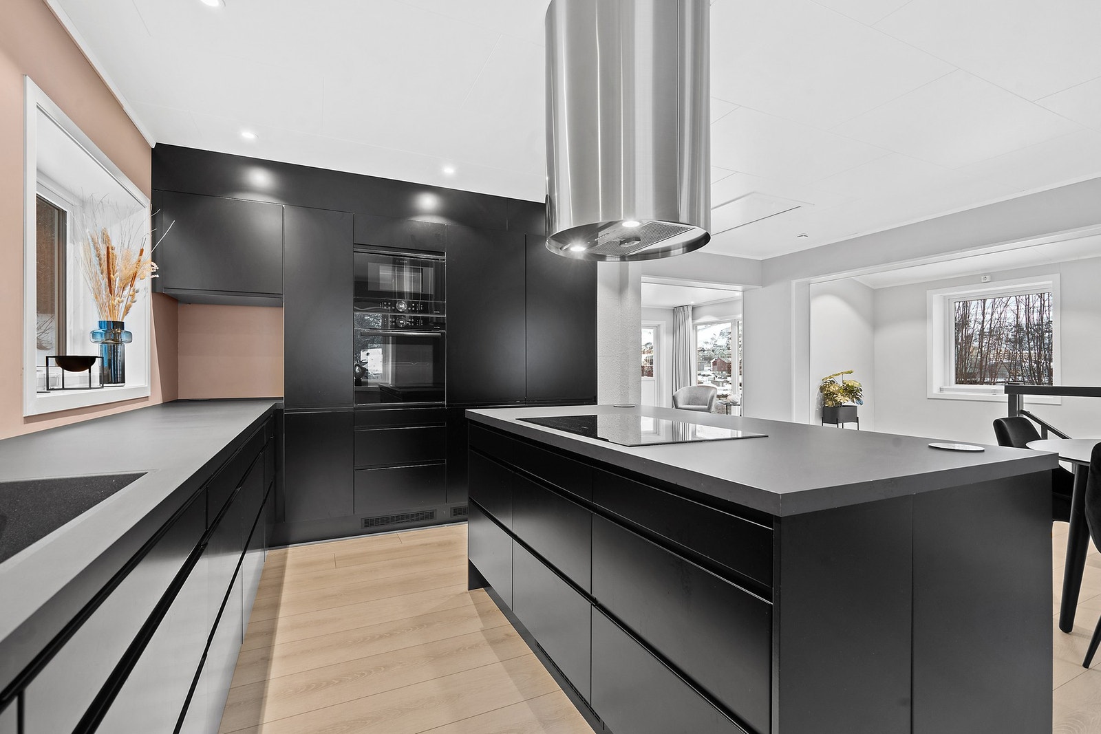 Kjøkkeninnredningen er holdt i en mørk, elegant stil med slette fronter og rikelig med skapplass. Galleribilde