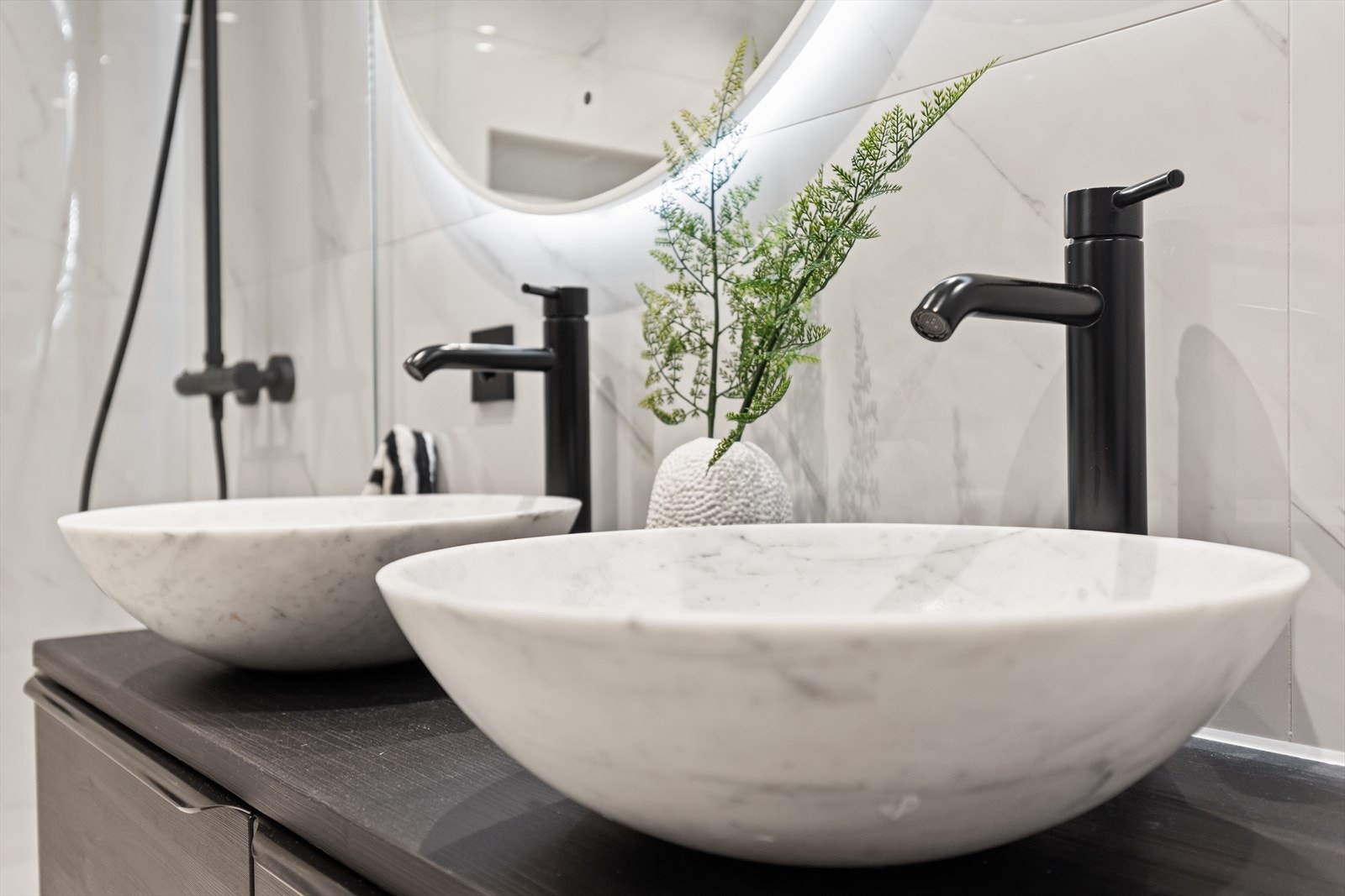 Detaljer fra badet, med doble, frittstående servanter og moderne armaturer. Galleribilde