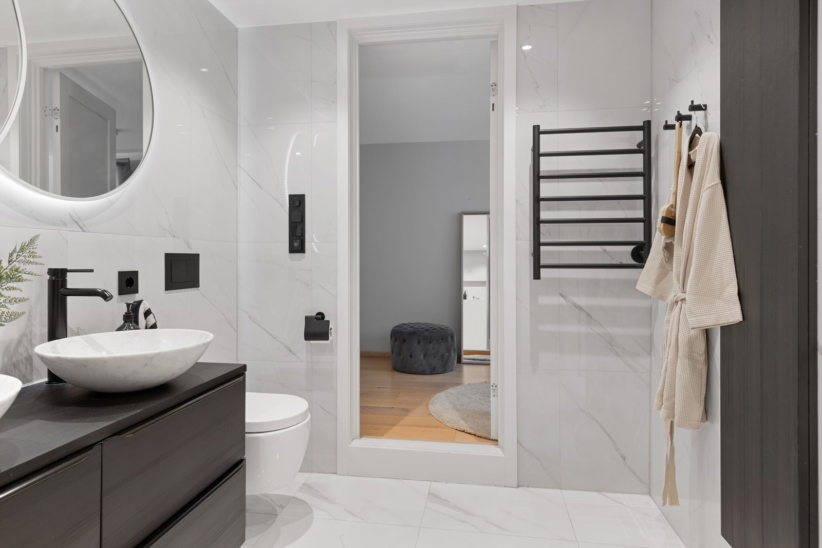 Badet er utstyrt med en stor servantinnredning, vegghengt toalett og downlights i himling. Galleribilde