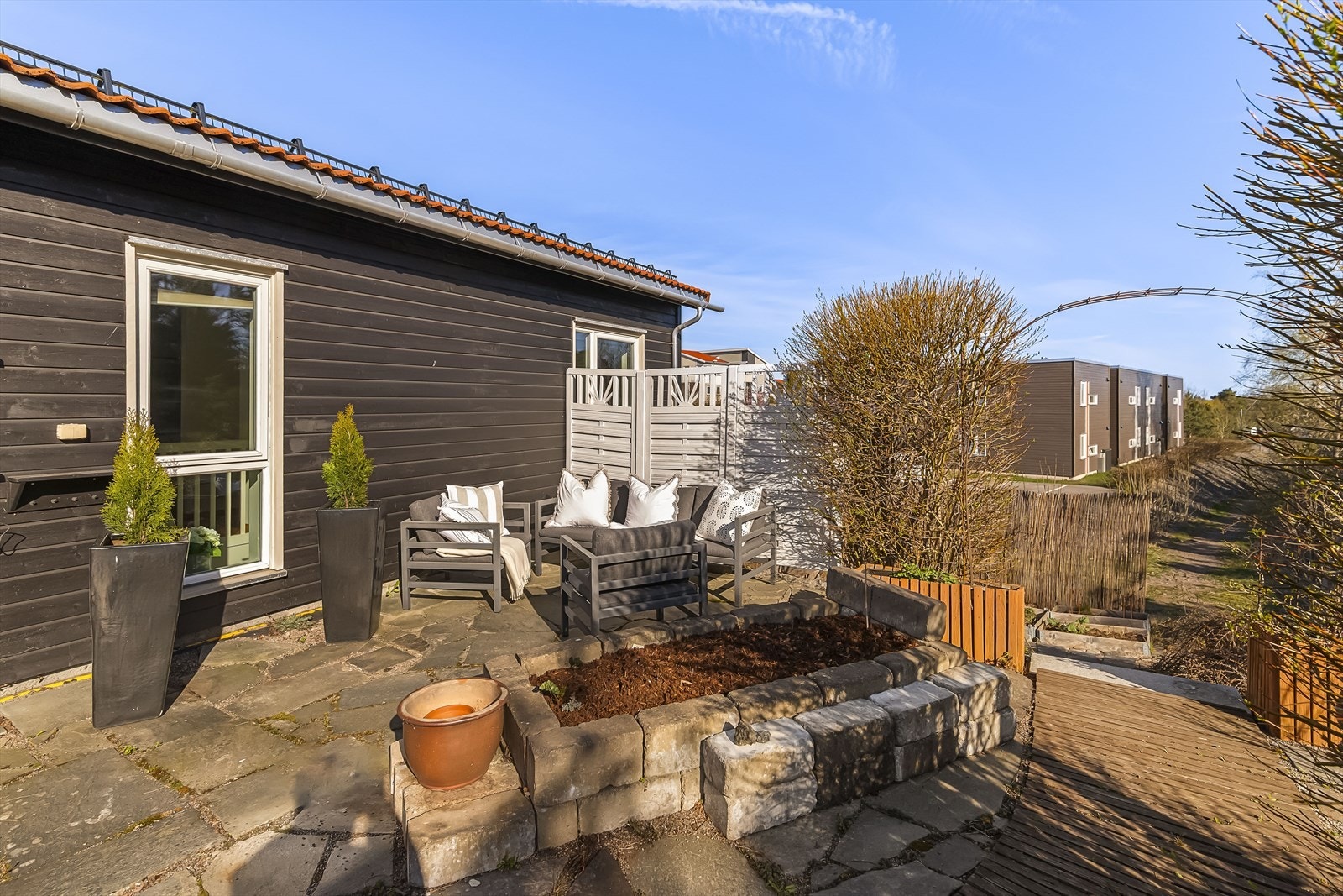 Fra boligens hovedetasje er det utgang til en romslig balkong som strekker seg rundt til baksiden, hvor man finner en skjermet hage belagt med steinheller. Galleribilde